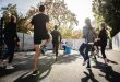 A group of people exercising outdoors together, engaging in fitness training on a sunny day.